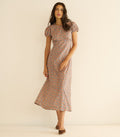 Woman wearing a floral dress against a beige background